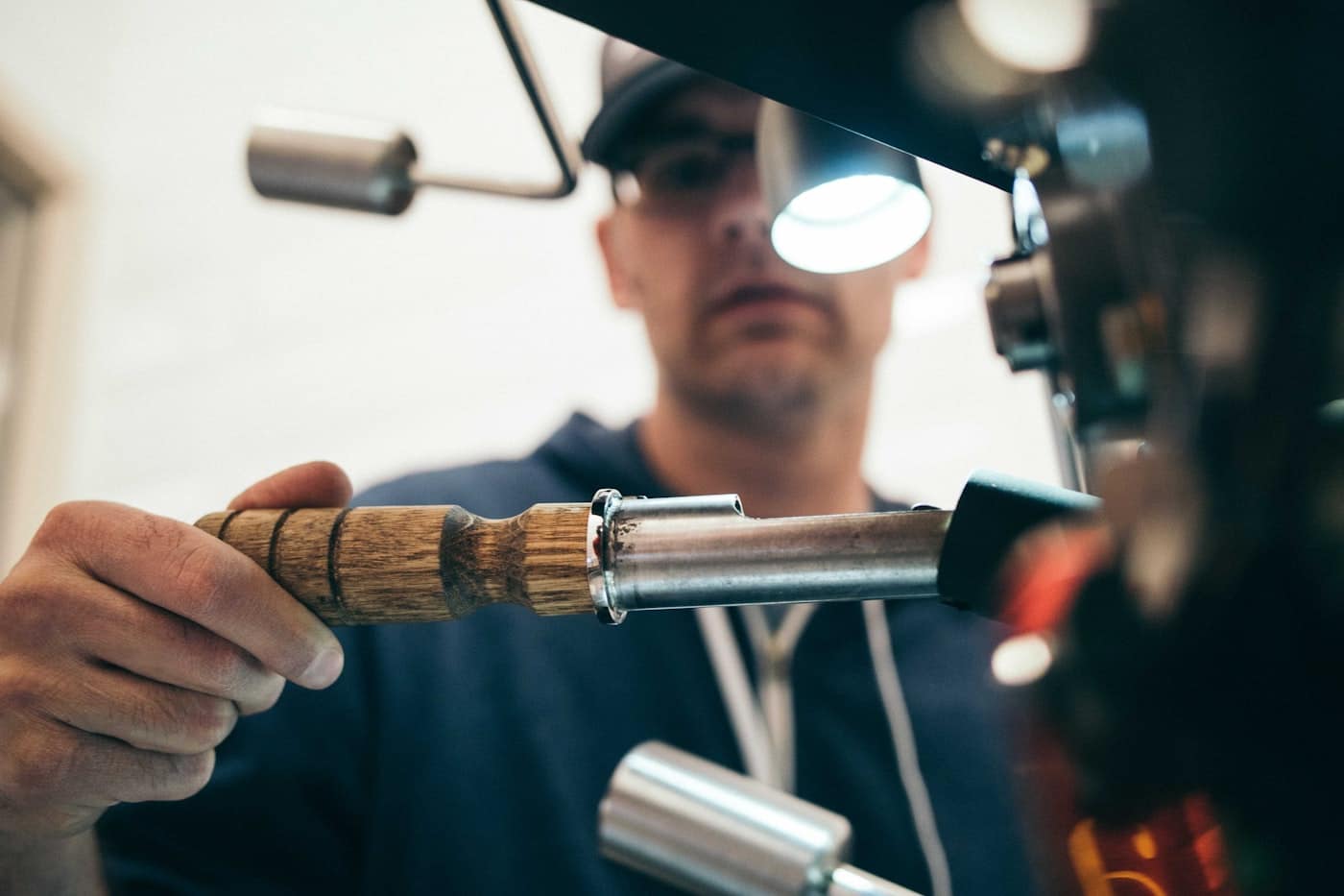 Main de l'artisan sur son outil, à l'établi